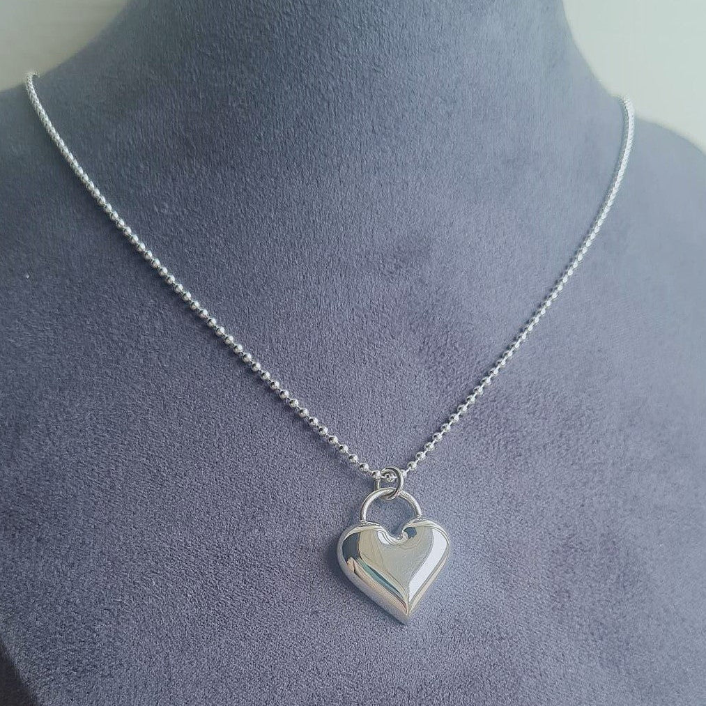 Silver heart-shaped pendant necklace on a mannequin