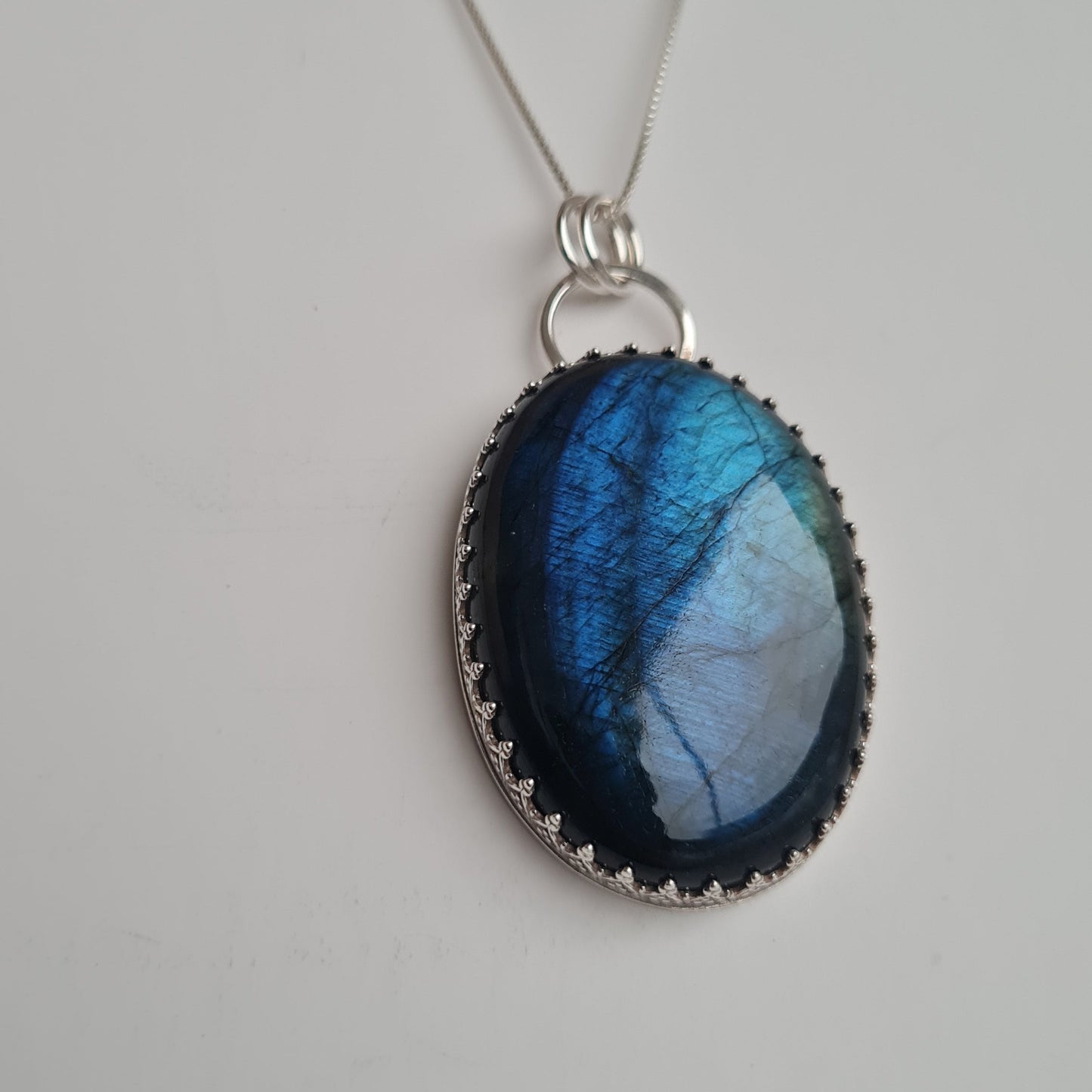 Oval shaped blue Labradorite stone in sterling silver bezel with silver chain